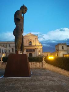 a statue in front of a building at night at Il Terrazzo di Apollo in Noto +70 photos