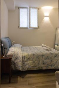 a bedroom with a bed and a table and two windows at amaMI in Milan