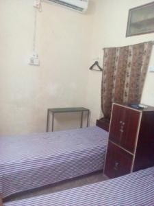- une chambre avec un lit violet et une table dans l'établissement APRO, à Kolkata