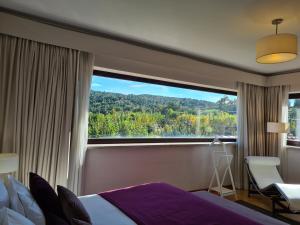 um quarto de hotel com uma grande janela e uma cama em Quinta de Santo Est�v�o Hotel Rural em Aguiar da Beira