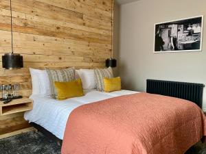 a bedroom with a large bed with a wooden wall at The Southern Belle in Brighton & Hove
