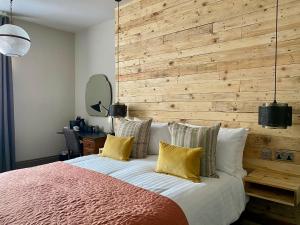 a bedroom with a large bed with a wooden wall at The Southern Belle in Brighton & Hove
