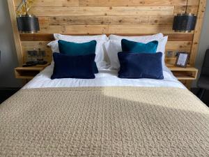 a large bed with two blue pillows on it at The Southern Belle in Brighton & Hove