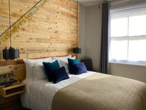 a bedroom with a large bed with a wooden wall at The Southern Belle in Brighton & Hove