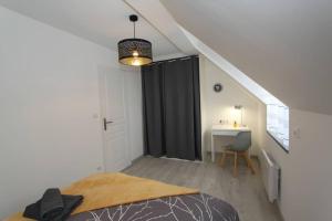 um quarto com uma cama com uma cortina preta e uma secretária em Le City by EasyEscale em Romilly-sur-Seine