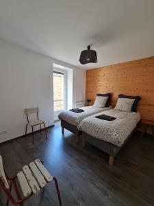 a bedroom with two beds and a chair in it at La Paulée à Pommard in Pommard