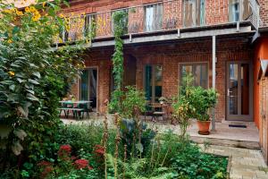 une maison en briques avec un jardin en face de celle-ci dans l'établissement Beautiful Backyard Remise, à Berlin