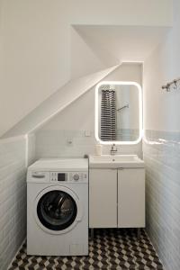 a laundry room with a washing machine and a sink at Beautiful and Cozy Remise for up to 6 Guests in Berlin