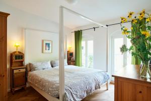 Un dormitorio con una cama y un jarrón de flores. en Beautiful and Cozy Remise for up to 6 Guests, en Berlín