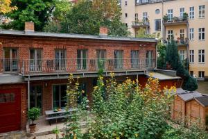 an apartment building with a balcony and a garden at Beautiful and Cozy Remise for up to 6 Guests in Berlin