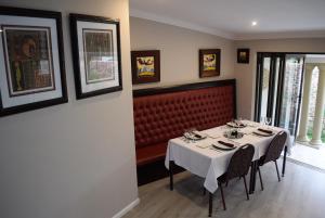 a dining room with a table and a red bench at African Moon Corporate House in Kempton Park