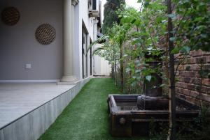 a garden with grass and a courtyard with trees at African Moon Corporate House in Kempton Park