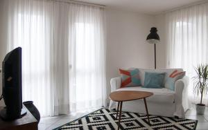 a living room with a white couch and a table at Gemütliche Wohnung mit sonniger Terrasse in Bietigheim-Bissingen