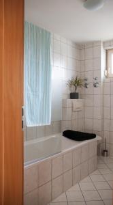 a bathroom with a bath tub with a window at Gemütliche Wohnung mit sonniger Terrasse in Bietigheim-Bissingen