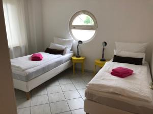 two beds in a room with a mirror at Gemütliche Wohnung mit sonniger Terrasse in Bietigheim-Bissingen
