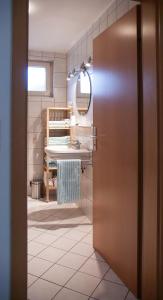 a bathroom with a door leading to a sink at Gemütliche Wohnung mit sonniger Terrasse in Bietigheim-Bissingen