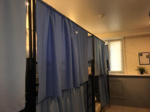 a bathroom with a shower with a blue shower curtain at Travel Inn Достоевская in Moscow