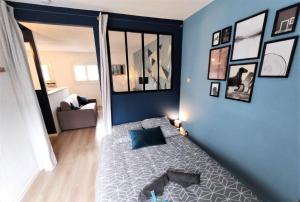 - une chambre avec un lit et des photos sur le mur dans l'établissement L'ÉGLANTINE - Proche Centre - Free Parking - Airbus, à Toulouse