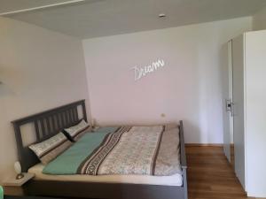 a bed in a room with a sign on the wall at Ferienwohnung Schneeweißchen an der Therme in Altenau
