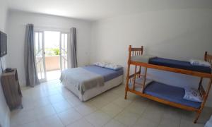 1 dormitorio con 2 literas y balcón en Quartos Privativos Pinheira - Hostel Pinheira, en Palhoça