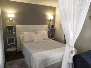 a bedroom with a white bed with a curtain at Marina Plaza 2 in Vilamoura
