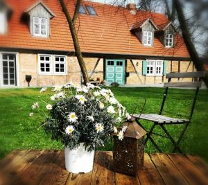 a vase of flowers on a wooden table with a bench at besinndich in Nebelin