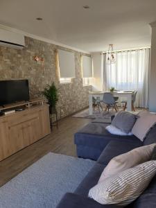 a living room with two blue couches and a television at Marina Plaza 2 in Vilamoura