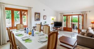 comedor y sala de estar con mesa y sillas en Villa Malva - Bonaire, Alcúdia, en Cielo de Bonaire 