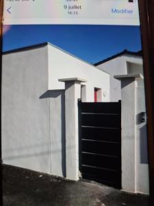 a white building with a black garage door at Appartement à Marignane in Marignane