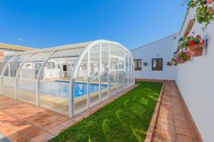 una casa de cristal con un patio con piscina en La Posada de Rivero, en Rivero de Posadas