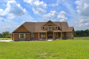ein Haus mit einem Gameradach auf einem grünen Feld in der Unterkunft Purple Skies Homestead in North Royalton