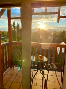 a balcony with a table and chairs and the sunset at Słupsk forest - PREMIUM APARTAMENTS - Kaszubska street 18 - Wifi Netflix Smart TV50 - pleasure quality stay in Słupsk