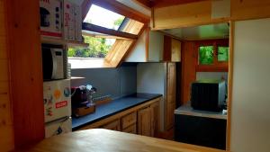 a small kitchen with a refrigerator and a microwave at chalet avec vue imprenable in Bagnères-de-Bigorre