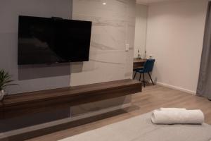 uma sala de estar com uma televisão de ecrã plano na parede em The Royal Bryanston em Joanesburgo