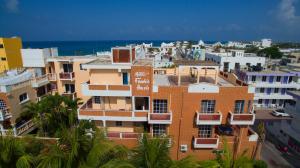 a group of buildings with the ocean in the background at Hotel Francis Arlene Adults Only in Isla Mujeres
