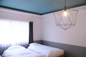 a bedroom with a bed and a pendant light at BEYOND HOTEL Takayama 4th - Vacation STAY 99852 in Takayama