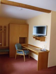 a room with a desk with a tv and a chair at Hotel Restaurant Weisbrod in Freinsheim