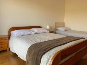 um quarto com 2 camas com lençóis brancos e uma mesa de cabeceira em Casa S & S em São Martinho do Porto