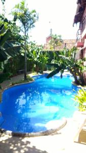 a large blue swimming pool with trees in the background at Pousada da Banda in São Sebastião