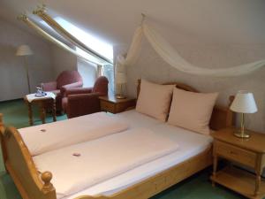 a bedroom with a large bed with a white canopy at Hotel Restaurant Weisbrod in Freinsheim