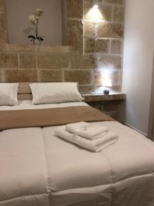 a bed with two white towels on top of it at Casetta dello Scrittore in Ostuni