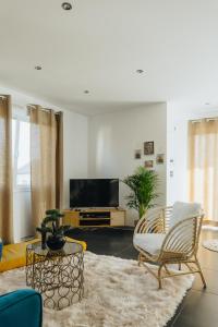 ein Wohnzimmer mit einem TV und einem Sofa in der Unterkunft La Villetta S Blotzheim - Appartement de Standing in Blotzheim