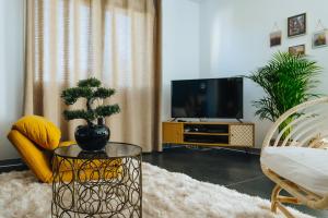 a living room with a tv and a glass table at La Villetta S Blotzheim - Appartement de Standing in Blotzheim