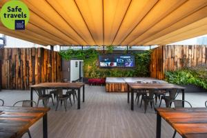 a patio with tables and chairs and a tv at Hotel MX roma in Mexico City