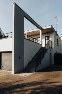 a white house with a staircase and a garage at La Villetta S Blotzheim - Appartement de Standing in Blotzheim