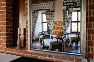 comedor con mesas, sillas y espejo en Zamek Uniejów, en Uniejów