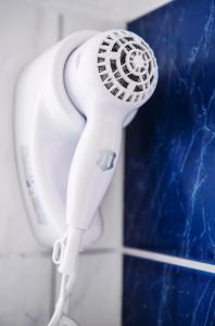a white hair dryer is hanging on a wall at Pension Bertha in Jena
