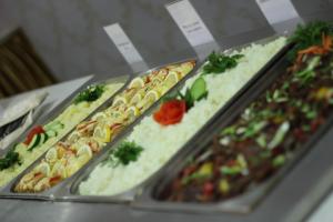 four trays of different types of food on a buffet at King Hotel Astana in Astana