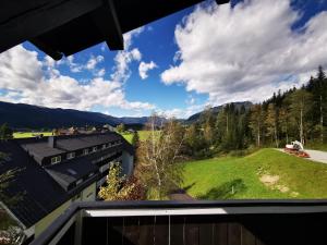 a view from the balcony of a house with a green hill at Alpenblick 30 in Bad Mitterndorf