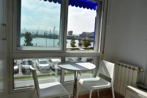 Habitación con mesa, sillas y ventana en Hostal Lucy, en Santander